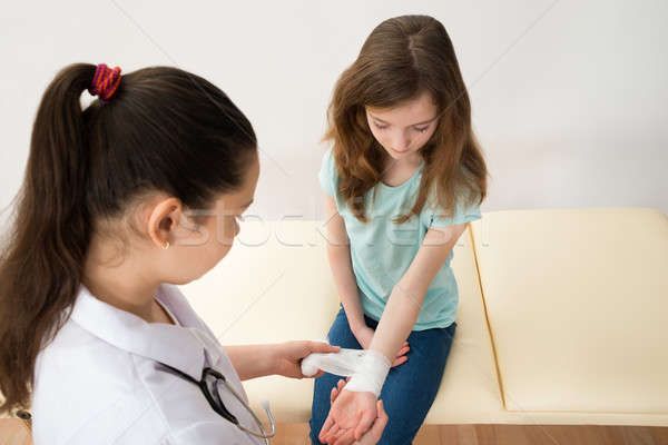 Doctor Bandaging Hands Of Girl Child Stock photo © AndreyPopov