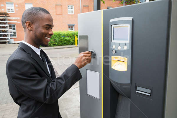 Businessman Inserting Coin Into Parking Meter Stock photo © AndreyPopov