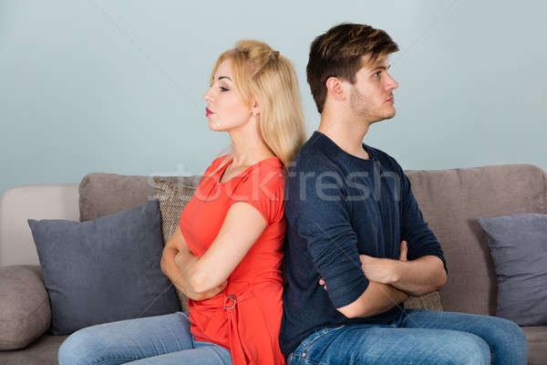 Unhappy Couple With Arms Crossed Sitting On Sofa Stock photo © AndreyPopov