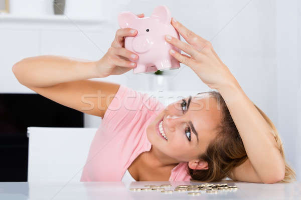 Happy Woman Emptying Her Piggybank Savings Stock photo © AndreyPopov