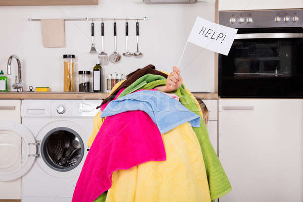 Woman Holding Help Flag With The Pile Of Clothes Stock photo © AndreyPopov