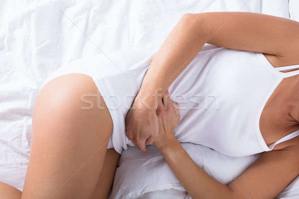 Kobieta snem bed ból brzucha widoku domu Zdjęcia stock © AndreyPopov