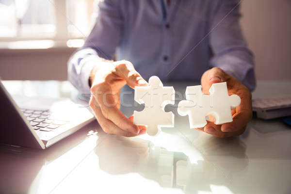 Businessperson's Hand Holding Two Jigsaw Puzzle Stock photo © AndreyPopov