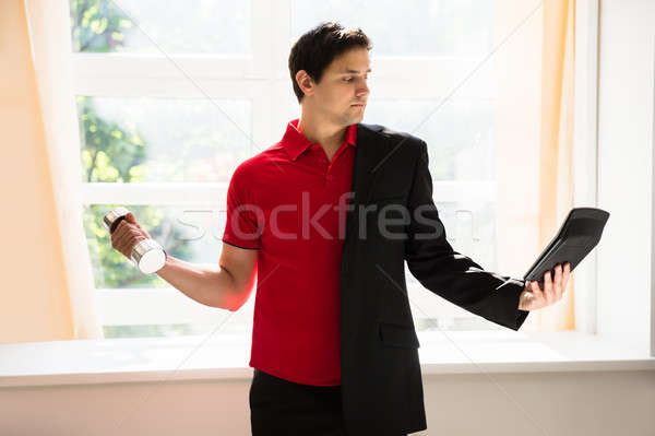 Businessman holding calculator exercising with dumbbell Stock photo © AndreyPopov