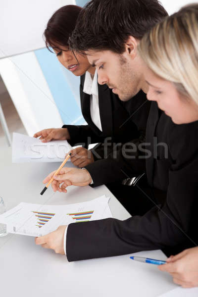 Group of business people looking at charts Stock photo © AndreyPopov