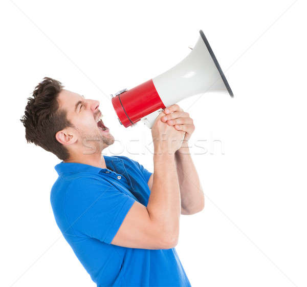 Stock photo: Man Screaming Into Bullhorn While Pointing Away