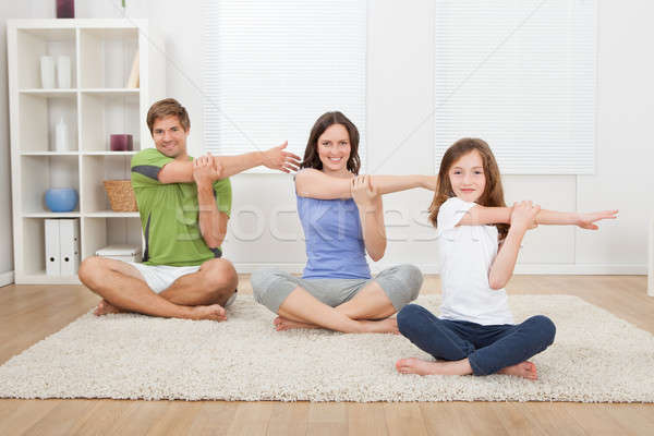 Smiling Family Performing Yoga On Rug Stock photo © AndreyPopov