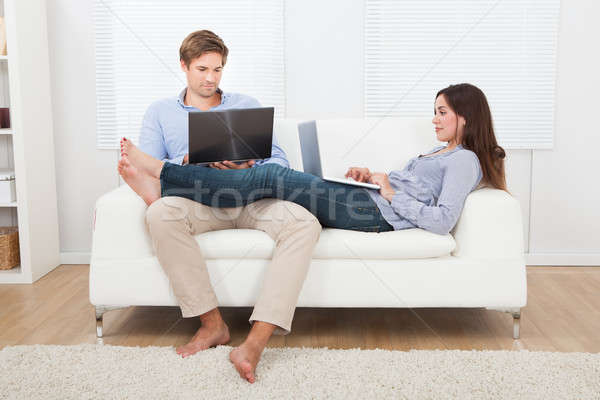Couple Using Laptops On Sofa Stock photo © AndreyPopov