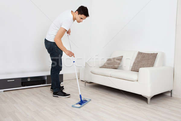Young Man Mopping Floor At Home Stock photo © AndreyPopov
