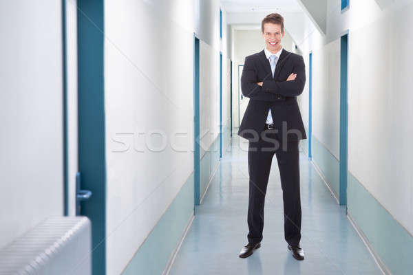 üzletember áll keresztbe tett kar iroda folyosó teljes alakos Stock fotó © AndreyPopov