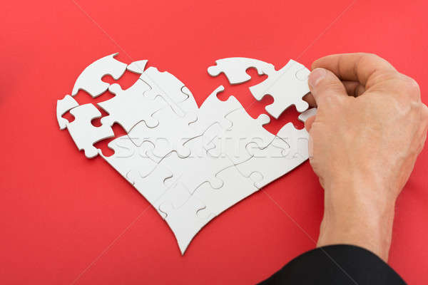 Person Solving Heartshape Jigsaw Puzzle Stock photo © AndreyPopov