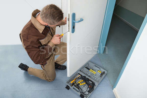 Carpenter Fixing Lock With Screwdriver Stock photo © AndreyPopov