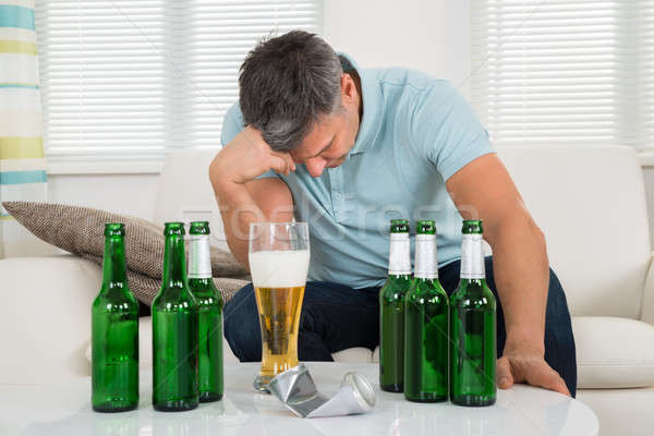 Man Sitting On Sofa In Front Of Beer Stock photo © AndreyPopov