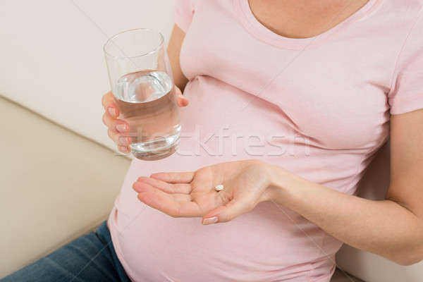 Pregnant Woman Hand With Glass Of Water And Vitamin Pill Stock photo © AndreyPopov