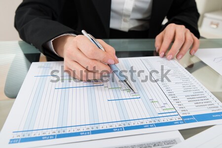 Close Up Of Businessman Filling Blank Cheque At Desk Stock photo © AndreyPopov