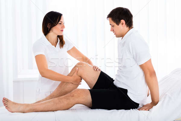 Therapist Massaging Man's Leg Stock photo © AndreyPopov