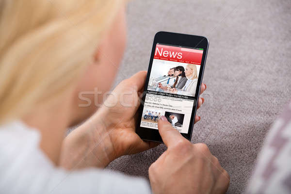 Woman Reading News On Mobilephone Stock photo © AndreyPopov