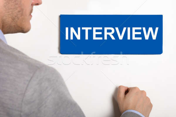 Businessman Knocking Door With Interview Nameplate Stock photo © AndreyPopov