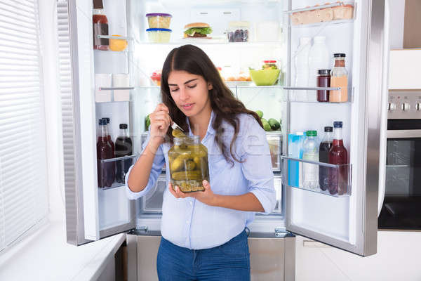 Mulher jovem alimentação jarra geladeira mulher casa Foto stock © AndreyPopov
