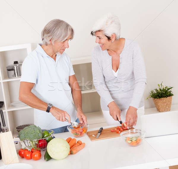 Stock photo: Middle-aged couple preparing a meal