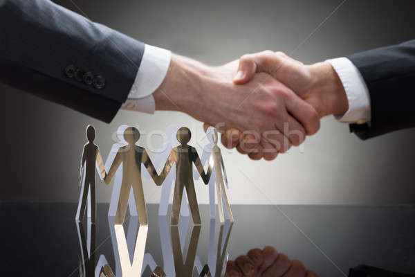 Businesspeople Shaking Hands With Paper Figures Stock photo © AndreyPopov