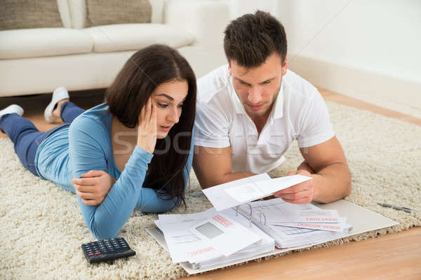 Stock photo: Worried Young Couple Calculating Their Bills At Home