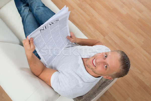 Man On Sofa With Newspaper Stock photo © AndreyPopov