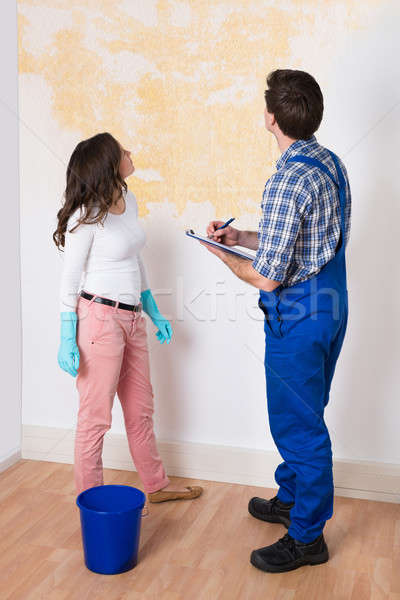 Worker Writing On Clipboard With Woman In House Stock photo © AndreyPopov