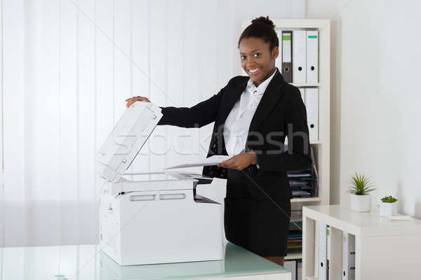 Smiling Businesswoman Using Photocopy Machine Stock photo © AndreyPopov