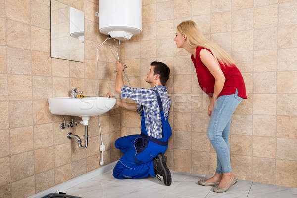 Male Worker Installing Electric Boiler With Screwdriver Stock photo © AndreyPopov