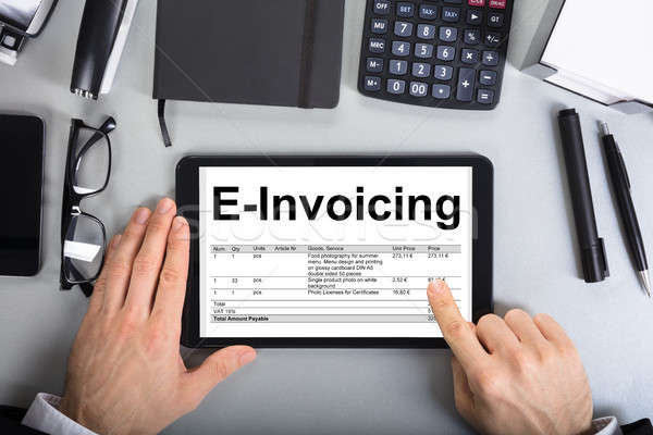 Businessman's Hands Going Through E-Invoicing On Digital Tablet Stock photo © AndreyPopov