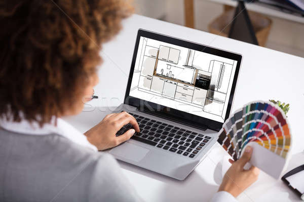 Stock photo: Female Architect Working On Color Selection For Kitchen