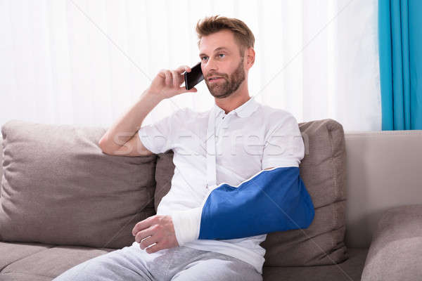 Man With Fractured Hand Talking On Mobile Phone Stock photo © AndreyPopov