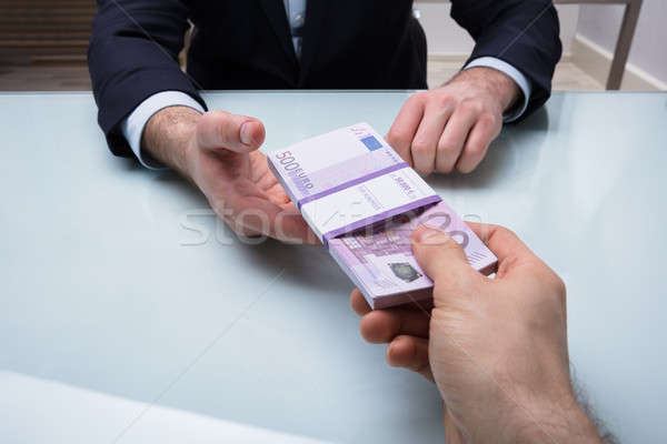 Person Giving Bundle Of Banknote Stock photo © AndreyPopov
