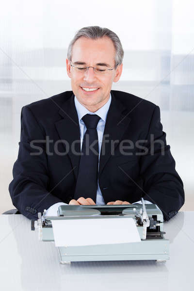 Mature businessman typing on typewriter Stock photo © AndreyPopov