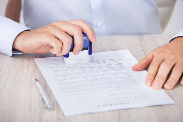 Cropped Image Of Businessman Stamping Contract Paper Stock photo © AndreyPopov