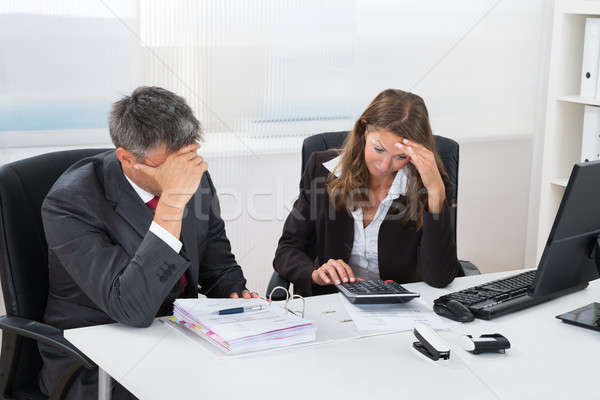 Two Businesspeople Doing Accounting At Desk Stock photo © AndreyPopov