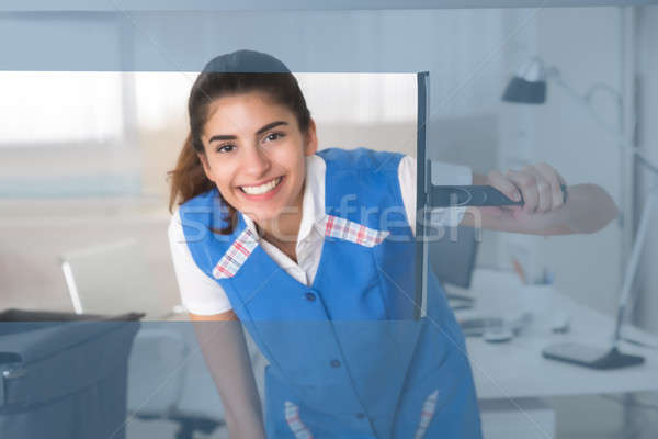 Smiling Female Worker Cleaning Glass Window With Squeegee Stock photo © AndreyPopov