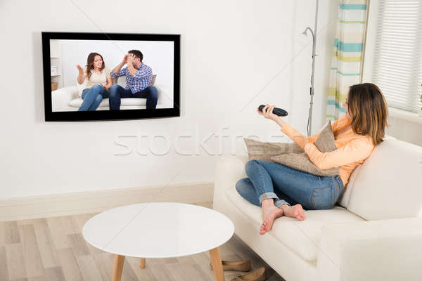 女子 看電視 房間 年輕女子 坐在 沙發 商業照片 © AndreyPopov
