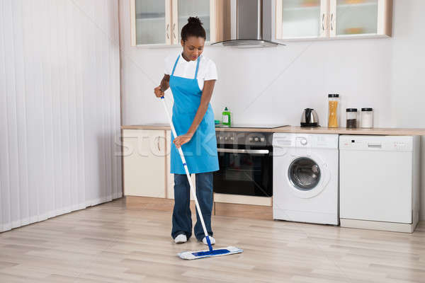 Female Janitor Mopping Floor In Kitchen Stock photo © AndreyPopov