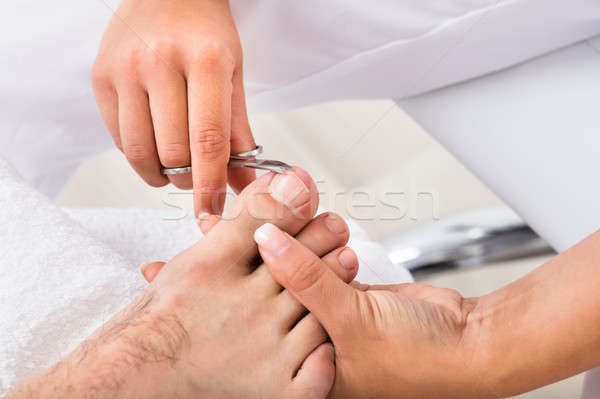 Manicurist With Scissors Trimming Person's Toenail Stock photo © AndreyPopov
