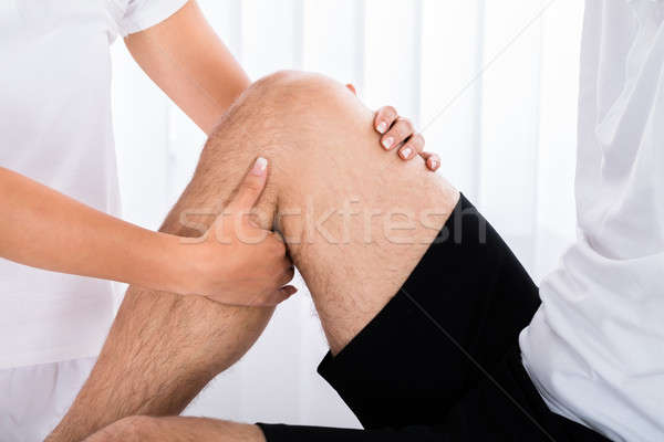 Therapist Hand Massaging Man's Leg In Spa Stock photo © AndreyPopov
