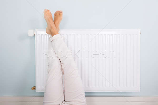 Kobieta w górę stóp biały radiator domu Zdjęcia stock © AndreyPopov