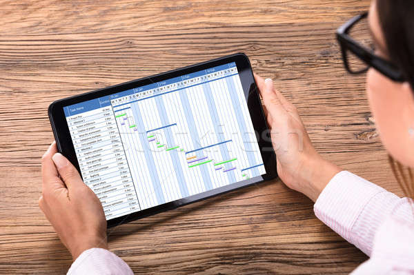 Businessperson Looking At Gantt Chart On Digital Tablet At Desk Stock photo © AndreyPopov