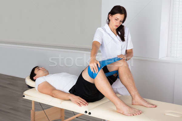 Therapist Helping Man While Exercising Stock photo © AndreyPopov