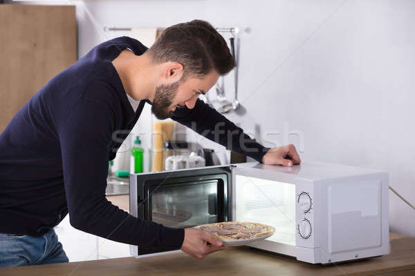 Człowiek pizza mikrofala piekarnik widok z boku Zdjęcia stock © AndreyPopov