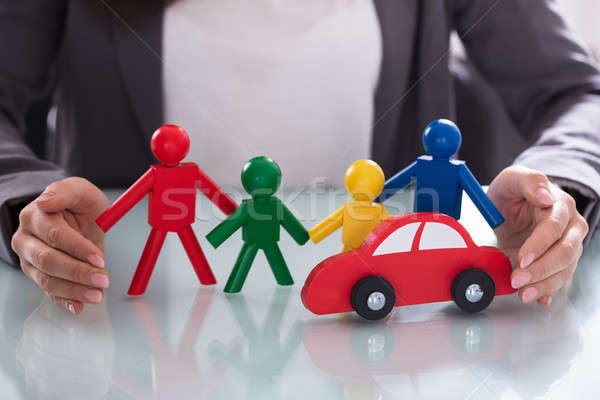 Businessperson Protecting Human Figures And Red Car Stock photo © AndreyPopov