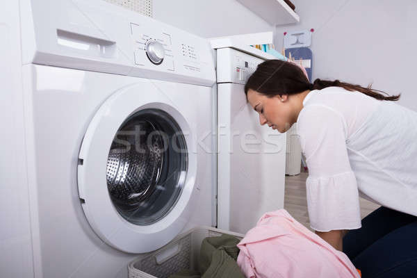 側面圖 筋疲力盡 年輕女子 洗衣店 房間 洗衣機 商業照片 © AndreyPopov