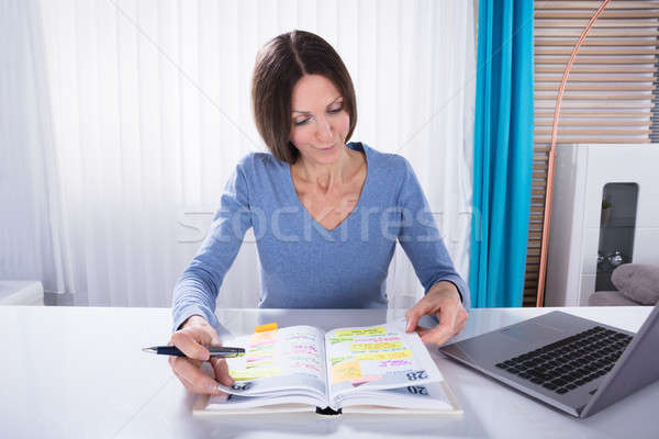 Mulher olhando calendário diário mulher madura programar Foto stock © AndreyPopov