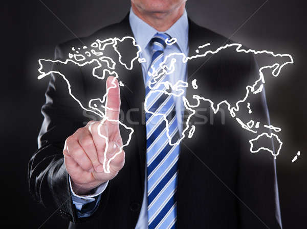 Businessman touching world map on the screen Stock photo © AndreyPopov